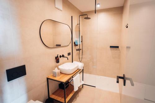 a bathroom with a sink and a shower at Pur-INN das Gästehaus in Purbach am Neusiedlersee