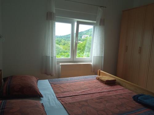 a bedroom with a large bed and a window at KATY&MLADEN in Baška