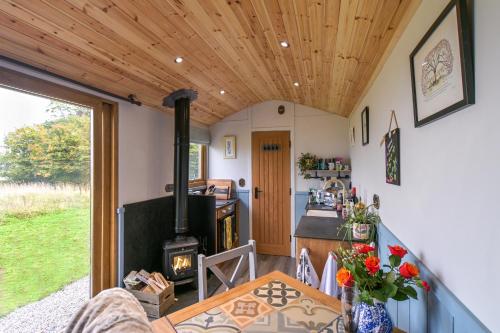 a living room with a wood stove in a house at Luxury Shepherd Hut in the Peak District in Bakewell