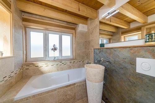 La salle de bains est pourvue d'une baignoire et d'une fenêtre. dans l'établissement Home des bois, à Ventron