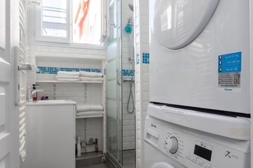 a white bathroom with a sink and a washing machine at Eiffel Tower view terrace Saint Germain des Pres in Paris