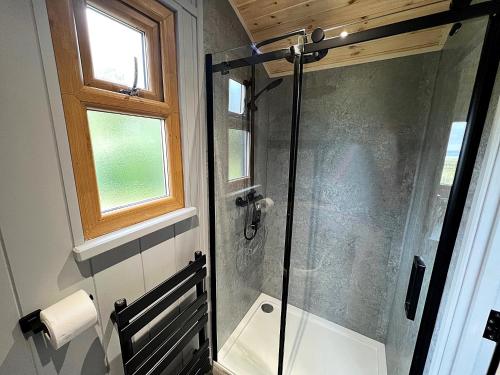 um chuveiro com uma porta de vidro na casa de banho em Luxury Shepherd Hut in the Peak District em Bakewell