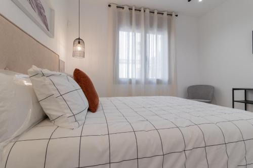 a bedroom with a large white bed with a window at La Morada Cordobesa in Córdoba
