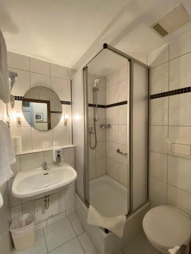 a bathroom with a shower and a sink and a toilet at Kurfürst am Kurfürstendamm in Berlin