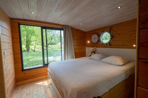 een slaapkamer met een bed in een kamer met een raam bij Le Village des Monédières in Chamberet