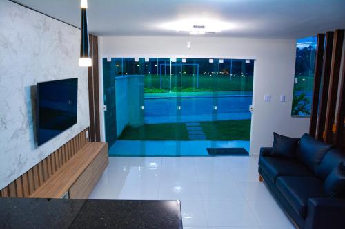 a living room with a couch and a swimming pool at Casa em Barreirinhas - Prime - Lençois Maranhenses - Temporada in Barreirinhas