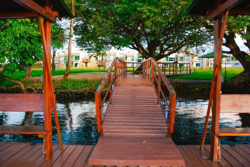 a wooden bridge over a river with two benches at Casa em Barreirinhas - Prime - Lençois Maranhenses - Temporada in Barreirinhas
