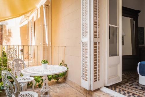 een patio met een tafel en stoelen op een balkon bij Hotel Medium Renaixença in Sitges