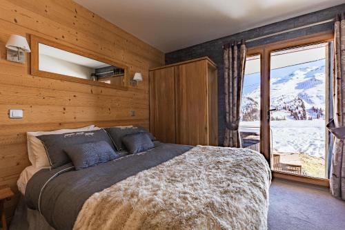 アヴォリアーズにあるLuxury Avoriaz Chalet with hot tubのベッドルーム1室(ベッド1台、大きな窓付)