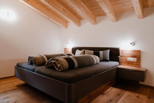 a bed with pillows on it in a room at Apart GuetGeanLossn in Längenfeld