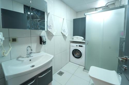 La salle de bains est pourvue d'un lavabo et d'un lave-linge. dans l'établissement PRIME INN CITY, à Melikgazi