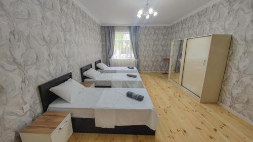 a hotel room with two beds and a mirror at Qafqaz Flower Villa in Gabala