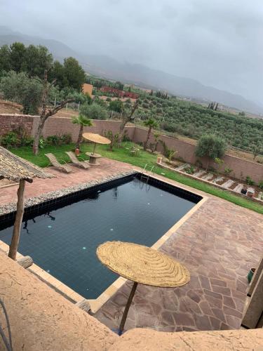 a swimming pool with umbrellas and a table and chairs at Offrez-vous un moment de détente in Marrakesh