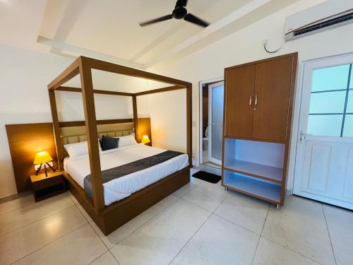 a bedroom with a canopy bed and a large window at The Yakshaa Kumartha in Rishīkesh