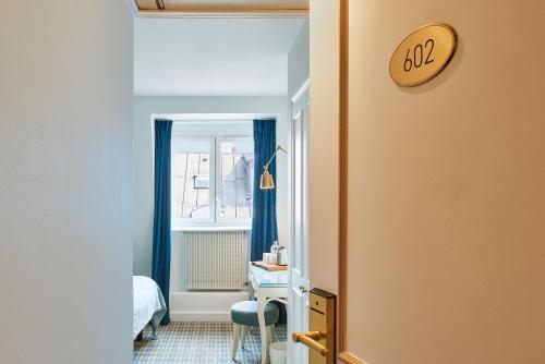 - un couloir avec une chambre dotée d'un lit et d'un bureau dans l'établissement Hotel Etoile Saint Ferdinand by Happyculture, à Paris