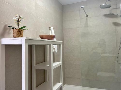 a bathroom with a shower and a white shelf with a sink at Precioso loft en Caión ROCHA, sobre la arena y el mar in Cayón