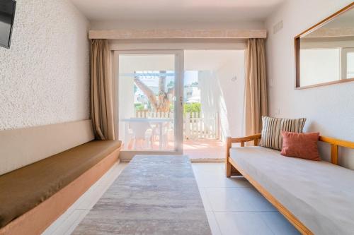 a room with a couch and a sliding glass door at Atlas Apartments Ibiza in Santa Eularia des Riu