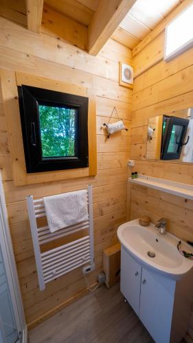 a bathroom with a white sink and a window at Le Village des Monédières in Chamberet