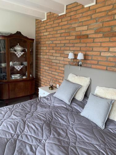 a bedroom with a bed and a brick wall at Villa Léna in Balatonederics