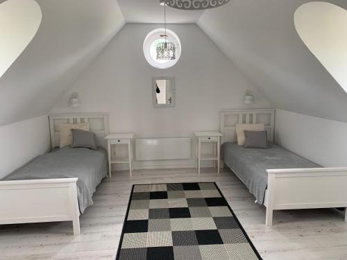 a attic bedroom with two beds and a checkered floor at Villa Léna in Balatonederics
