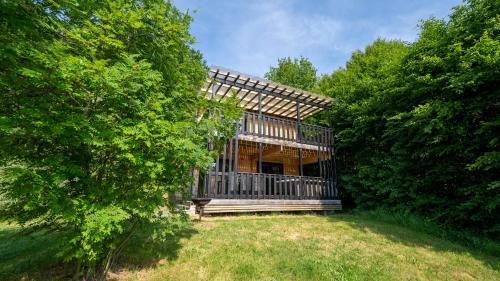a house in the middle of a field with trees at Le Village des Monédières in Chamberet