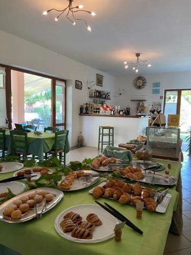 una mesa con platos de pan y bollería. en Bed & Breakfast Alex en Porto Azzurro