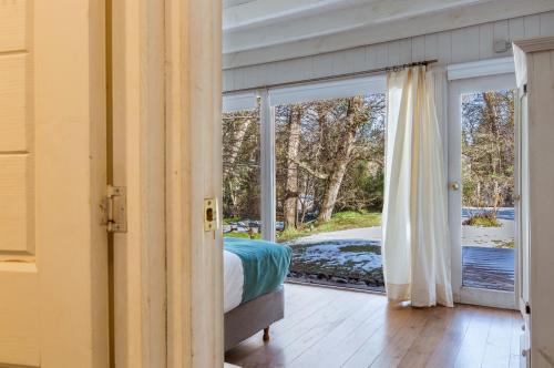 1 dormitorio con 1 cama y puerta corredera de cristal en BOG El Granero en Villa La Angostura