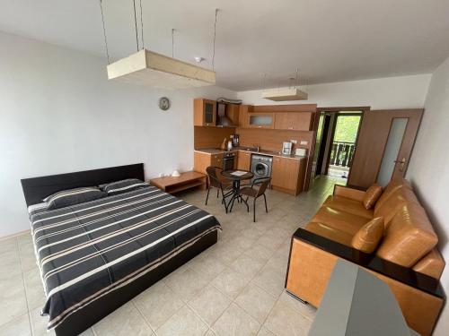 1 dormitorio con cama, sofá y cocina en Kavarna Paradise Apartments, en Kavarna