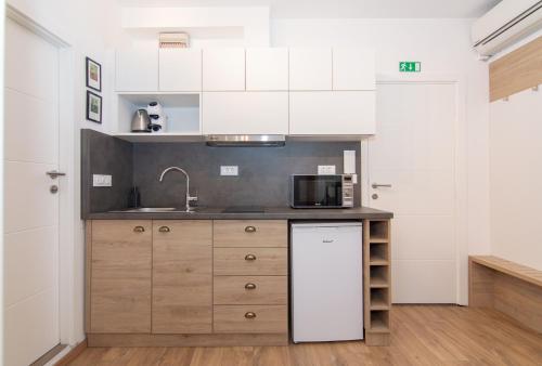 a kitchen with a sink and a microwave at Casa Mia - Apartments & Suites in Koper