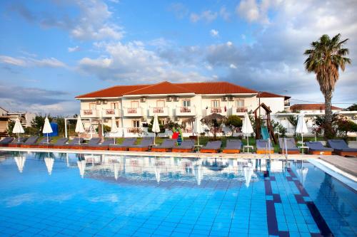a large swimming pool with chairs and a hotel at Akis Studios Alykes in Alykes