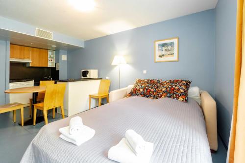 1 dormitorio con 1 cama blanca y cocina en Villa Mariale by Popinns, en Lourdes
