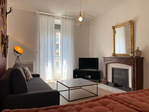 a living room with a couch and a fireplace at Le Condorcet. Charme et confort à Championnet in Grenoble