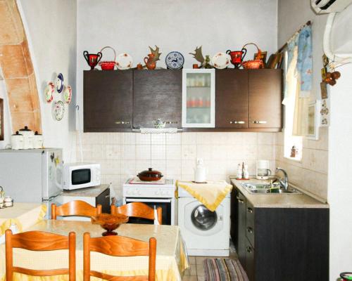 uma cozinha com uma mesa e cadeiras e um lavatório em Traditional House in Laerma em Láerma