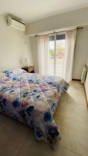 a bedroom with a bed and a window at Duplex Sarmiento in Olavarría