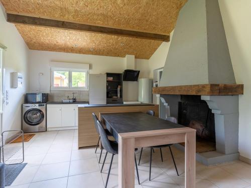 - une cuisine avec une table et une cheminée dans l'établissement Maison de 40m² à Biscarrosse - Proche lac, pistes cyclables, plage - Accueille 4 pers. - Animaux OK - FR-1-319-484, à Biscarrosse