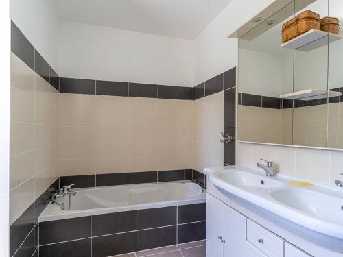 une salle de bain avec une baignoire, un lavabo et un miroir dans l'établissement Maison 6 pers. à Biscarrosse, proche lac, jardin, BBQ, WiFi, parking, ménage inclus - FR-1-319-479, à Biscarrosse
