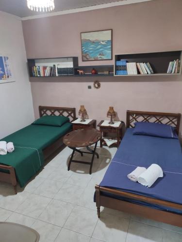 a bedroom with two beds and a table and chairs at LHMNIA GH in Néa Koútali