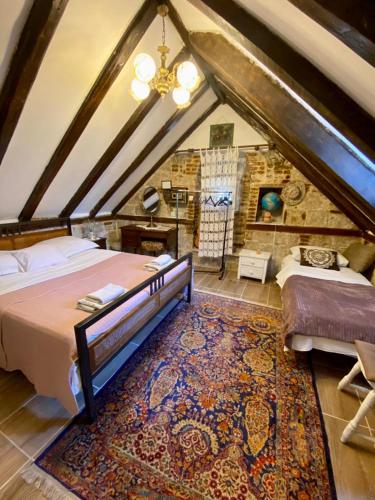 a attic bedroom with two beds and a rug at Kovacic Rooms in Split