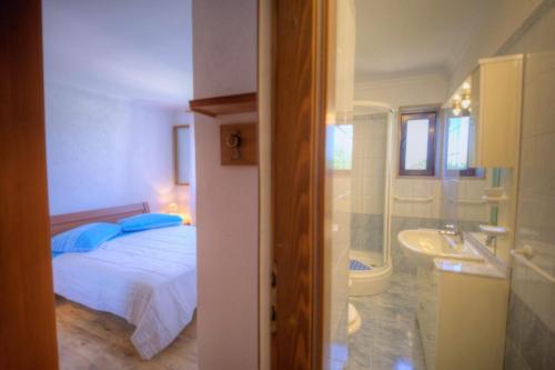 a bedroom with a bed and a bathroom with a sink at Casa Cerin with Private Pool in Barat