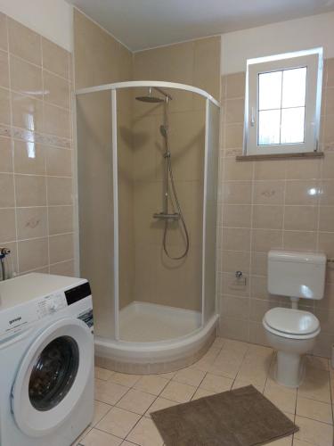 a bathroom with a shower and a washing machine at APARTMA MARI in Bertoki