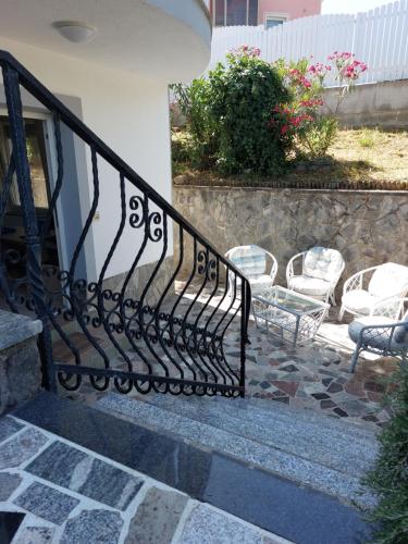a wrought iron railing on a staircase with chairs at APARTMA MARI in Bertoki