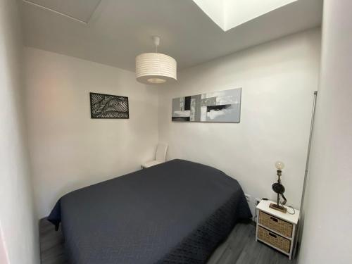- une chambre avec un lit noir et une lampe dans l'établissement La Ciotat T2 à proximité du port, à La Ciotat