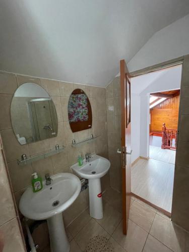 Baño con 2 lavabos y espejo en CONSTANTINESCU A., en Buşteni