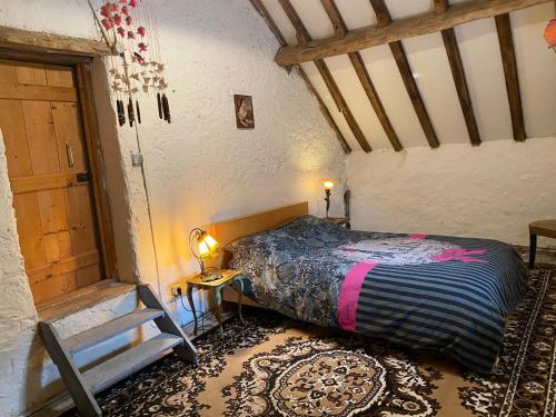 une chambre avec un lit dans une pièce avec un escalier dans l'établissement Maison L’Atelier, à Thollet