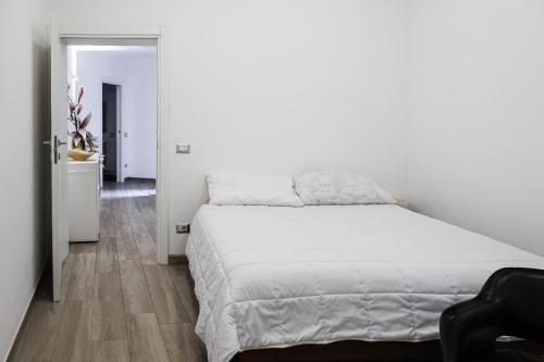 1 dormitorio con cama blanca y pasillo en Piagentina Residence 1 en Florence