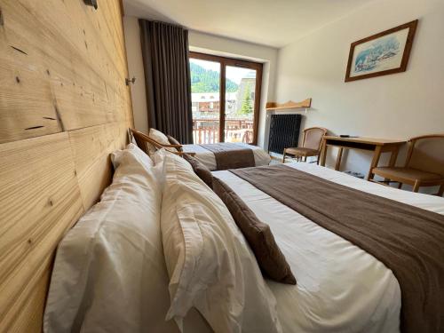 a hotel room with two beds and a desk at Aiguille Noire in Valloire