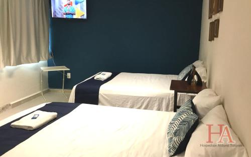 um quarto de hotel com duas camas e uma televisão em Hospedaje Aldana - Habitación L E R D O en zona centro em Tuxpan de Rodríguez Cano