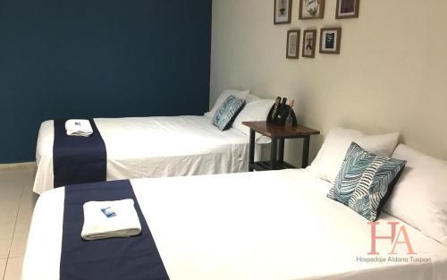 Zimmer mit 3 Betten und einem kleinen Tisch in der Unterkunft Hospedaje Aldana - Habitación L E R D O en zona centro in Tuxpan de Rodríguez Cano