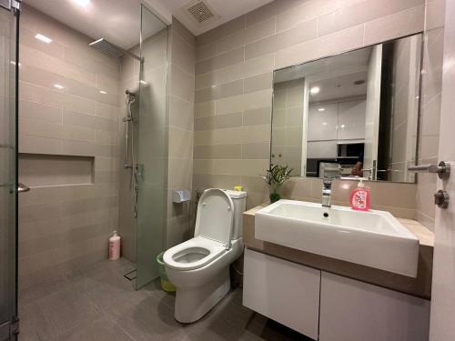 a bathroom with a toilet and a sink and a mirror at One Bukit Ceylon by Home Suites in Kuala Lumpur