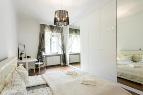 a white bedroom with a bed and a mirror at Golden Apartments Warsaw - Stylish and Luxury Apartment - Podwale in Warsaw